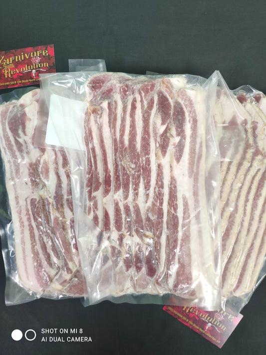 Multiple packages of thick cut bacon, wrapped and placed side by side.